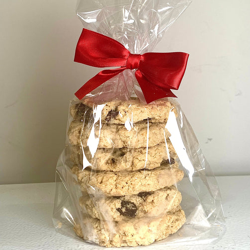 Stack of cookies in clear cellophane bag with red ribbon on white background